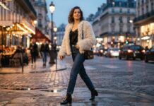Woman wearing a neutral faux-fur jacket and dark denim jeans