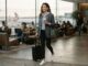 Woman wearing a wool blazer over a hoodie and leggings for travel